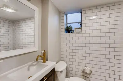 a bathroom with a sink and a toilet and a mirror at Guest Suite With Kitchenette And A 5 star Location in Denver