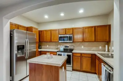 a kitchen with wooden cabinets and a stainless steel refrigerator at Capital Hill Condo 5 star location With Balcony in Denver