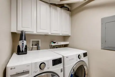a washer and dryer in a kitchen with white cabinets at Capital Hill Condo 5 star location With Balcony in Denver