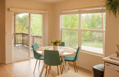 a dining room with a table and chairs and windows at Spacious Oasis near Red Rocks and Downtown Denver in Lakewood