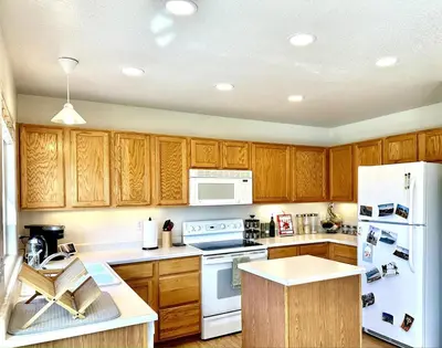 a kitchen with wooden cabinets and white appliances at Spacious Oasis near Red Rocks and Downtown Denver in Lakewood