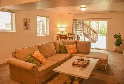 a living room with a brown couch and a table at Spacious Oasis near Red Rocks and Downtown Denver in Lakewood