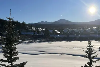 a field covered in snow with houses and trees at Luxury condo with stunning views! in Fraser