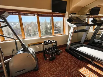 a room with two bunk beds and a treadmill at Cozy Mountain Suite - hot tub, pool, gym - mins to lift in Keystone