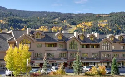 a large building with cars parked in front of it at Cozy Mountain Suite - hot tub, pool, gym - mins to lift in Keystone