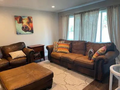 a living room with a brown couch and a chair at Island in the City - AWESOME 3 BR 2 BA 15 Min from DIA DT Anschutz in Commerce City