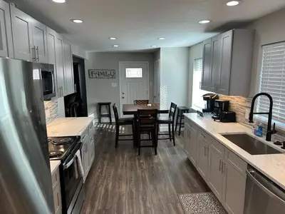 a kitchen with a table and chairs and a counter top at Island in the City - AWESOME 3 BR 2 BA 15 Min from DIA DT Anschutz in Commerce City