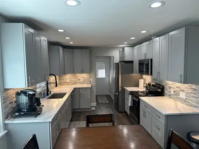 a large kitchen with white cabinets and counter tops at Island in the City - AWESOME 3 BR 2 BA 15 Min from DIA DT Anschutz in Commerce City