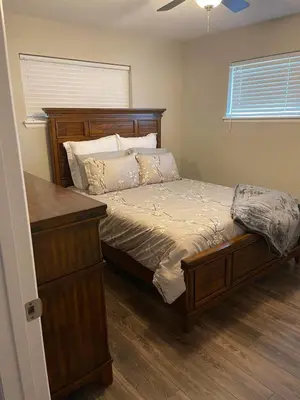 a bedroom with a bed with a wooden headboard and a dresser at Island in the City - AWESOME 3 BR 2 BA 15 Min from DIA DT Anschutz in Commerce City