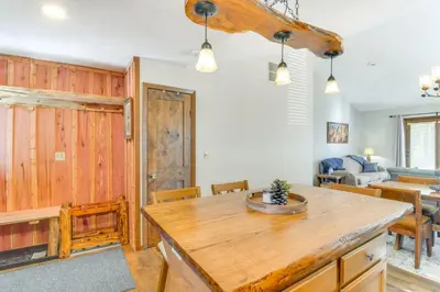 a kitchen and living room with a wooden table at Family-Friendly Retreat with Balcony in Fraser! in Fraser