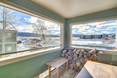 a room with windows with a bench and a pile of logs at Family-Friendly Retreat with Balcony in Fraser! in Fraser