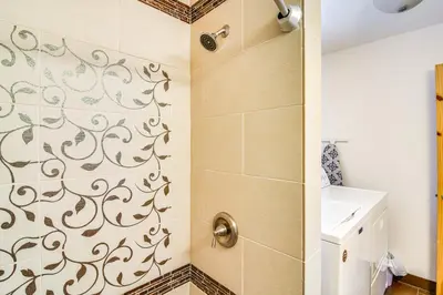 a bathroom with a shower with a pattern on the wall at Hike, Ski and Explore Townhome with Yard in Fraser! in Fraser