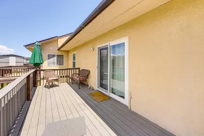 a house with a deck with an umbrella and a chair at Hike, Ski and Explore Townhome with Yard in Fraser! in Fraser