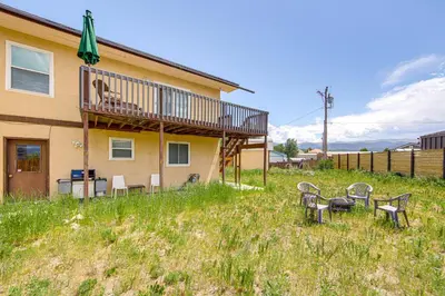 a house with a deck with chairs and a table at Hike, Ski and Explore Townhome with Yard in Fraser! in Fraser