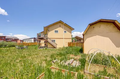 a house in the middle of a field of grass at Hike, Ski and Explore Townhome with Yard in Fraser! in Fraser