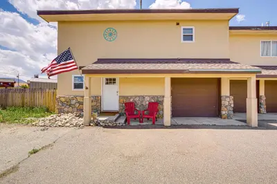 a house with two red chairs and an american flag at Hike, Ski and Explore Townhome with Yard in Fraser! in Fraser