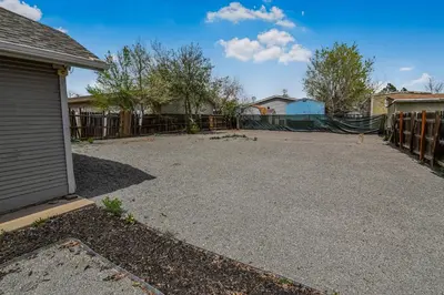 an empty driveway in front of a fence at 3 bed home with huge yard near Hidden Lake in Denver