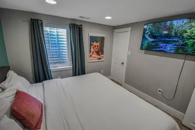 a bedroom with a bed and a flat screen tv at 3 bed home with huge yard near Hidden Lake in Denver