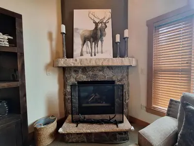 a living room with a fireplace with a picture of a deer at 3BR Red Hawk Townhome - Gondola Access townhouse in Keystone