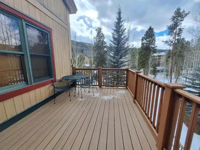 a wooden deck with a table and chairs on it at 3BR Red Hawk Townhome - Gondola Access townhouse in Keystone