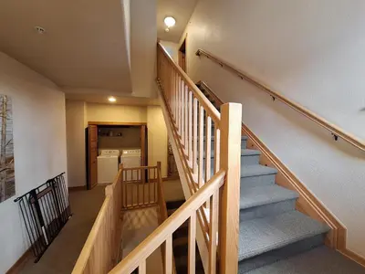 a winding staircase in a home with wooden railings at 3BR Red Hawk Townhome - Gondola Access townhouse in Keystone