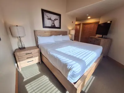 a bedroom with a large bed and a television at 3BR Red Hawk Townhome - Gondola Access townhouse in Keystone