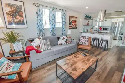 a living room with a gray couch and a table at Charming Cowboy Bunkhouse in Denver in Denver