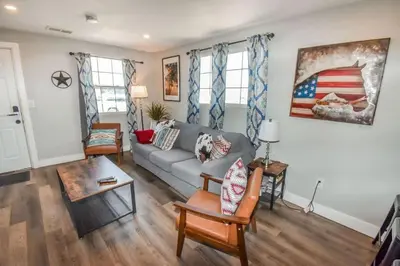 a living room with a couch and an american flag painting at Charming Cowboy Bunkhouse in Denver in Denver