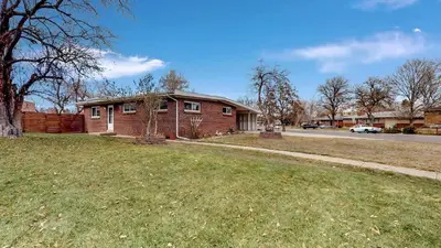 a brick house on a street with a grass yard at Charming Three Bedroom Home in Littleton in Littleton
