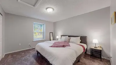 a bedroom with a large white bed with a window at Comfortable Family Friendly Home on Quincy Reservoir in Aurora