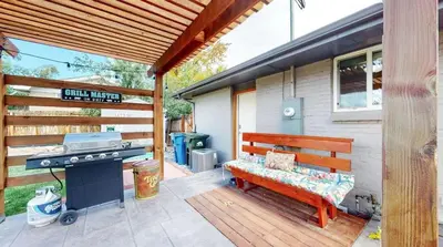 a wooden bench sitting on a patio with a grill at Charming four bedroom home with large yard and plenty of room for family in Centennial