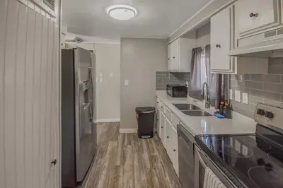 a kitchen with white cabinets and a stainless steel refrigerator at Spacious ranch on large lot near water world in Federal Heights