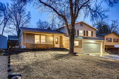 a house with a tree in the front yard at The Arvada Retreat with HotTub, Games, Gym and Lounge in Arvada