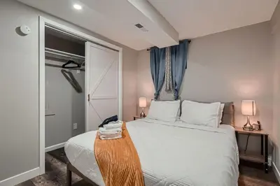 a bedroom with a white bed with a wooden table at The Arvada Retreat with HotTub, Games, Gym and Lounge in Arvada