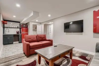 a living room with a red couch and a table at The Arvada Retreat with HotTub, Games, Gym and Lounge in Arvada