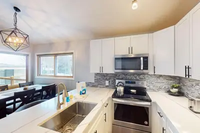 a kitchen with a sink and a stove top oven at Flying Dutchman - Snow Owl Condo in Keystone