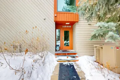 an orange door on a house in the snow at Flying Dutchman - Snow Owl Condo in Keystone
