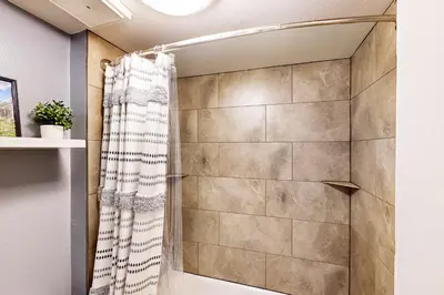 a shower with a shower curtain in a bathroom at Flying Dutchman - Snow Owl Condo in Keystone