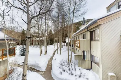 a snow covered yard next to a building at Flying Dutchman - Snow Owl Condo in Keystone