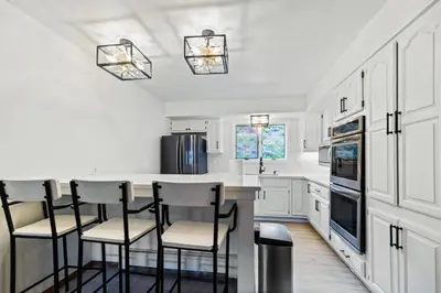 a kitchen with white cabinets and a bar with stools at Spacious Keystone Family Escape Great Location in Keystone