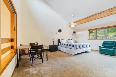 a bedroom with a bed and a table and a chair at Spacious Keystone Family Escape Great Location in Keystone