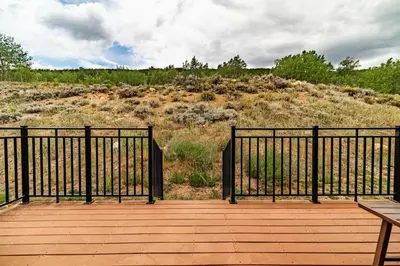 a wooden boardwalk with a black fence and a bench at Spacious Keystone Family Escape Great Location in Keystone