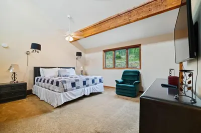 a bedroom with a bed and a green chair at Spacious Keystone Family Escape Great Location in Keystone