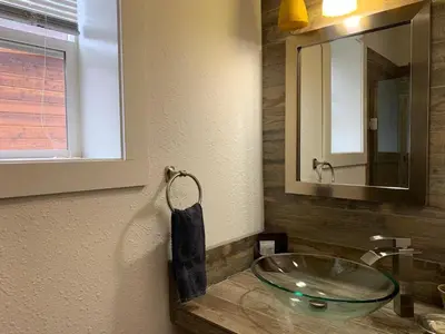 a bathroom with a bowl sink and a mirror at Native Spirit Cabin at Base Camp in Dumont