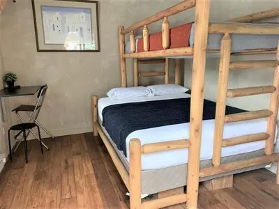 a bedroom with two bunk beds and a desk at Native Spirit Cabin at Base Camp in Dumont