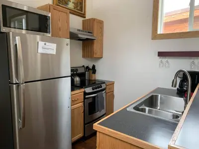 a kitchen with a stainless steel refrigerator and a sink at Native Spirit Cabin at Base Camp in Dumont
