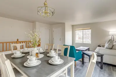 a dining room and living room with a table and chairs at 5 Mi to Cherry Creek State Park Cozy Family Home! in Aurora