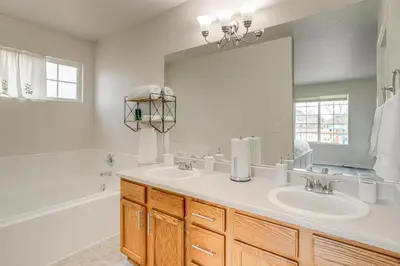 a bathroom with two sinks and a large mirror at 5 Mi to Cherry Creek State Park Cozy Family Home! in Aurora