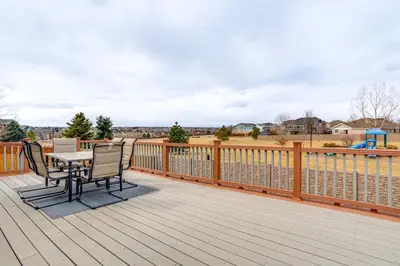 a wooden deck with a table and chairs on it at 5 Mi to Cherry Creek State Park Cozy Family Home! in Aurora
