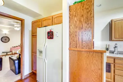 a kitchen with a white refrigerator and wooden cabinets at 7 Mi to Dtwn Denver Lakefront Gem with Dock! in Denver